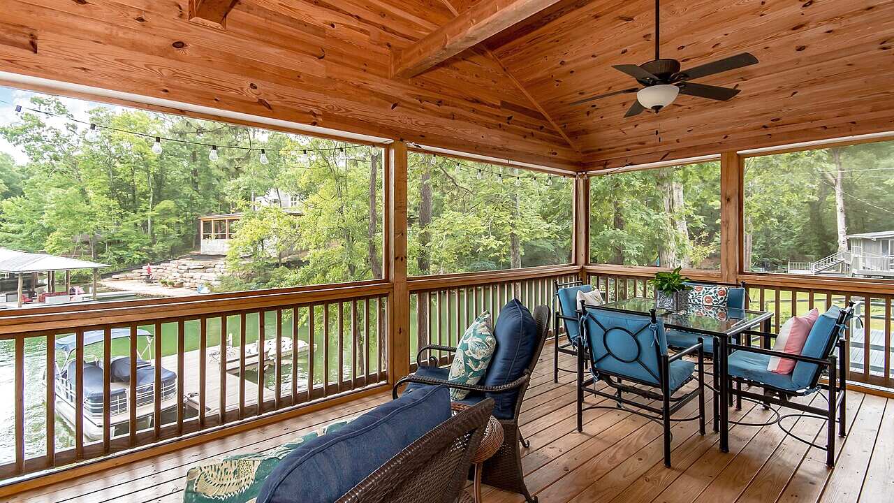 Waterfront house with a screened porch and dock in soft morning light after overnight rain